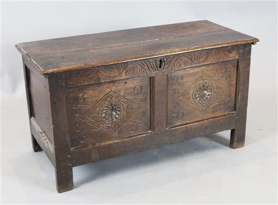 A late 17th century oak coffer, the front with two panels carved with lozenges and fleur de lys, W.96cm